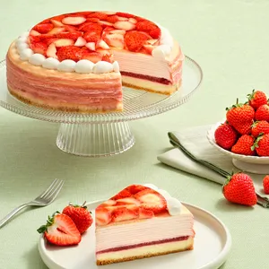 Sliced cake on glass stand with fresh strawberries and forked plate nearby