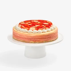 Whole strawberry mille crêpes cake with cream border, front view on white stand