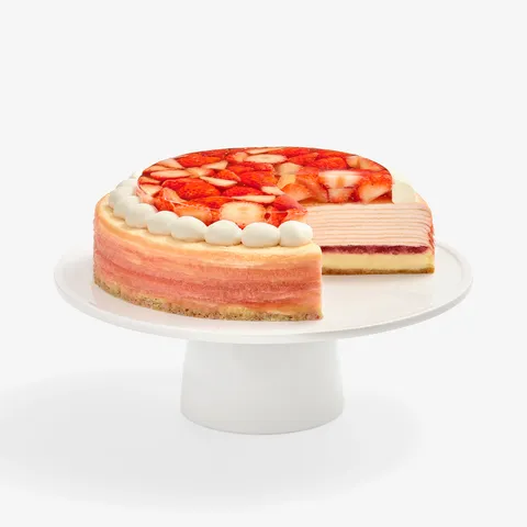Whole cake with one slice removed, showing crêpe layers, on white cake stand