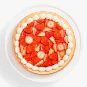 Overhead view of cake showing strawberry topping and whipped cream border