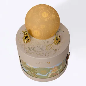 Lady M gift box with glowing moon topper in warm ambient lighting.