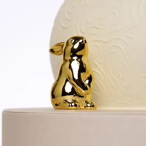 Close-up of Lady M gift box with candle and gold rabbit figurines on lid