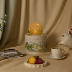 Lady M gift box, mooncakes, and Mille Crêpes slice on table with tea being poured