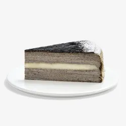 Single slice of Sesame Mochi Mille Crêpes cake on white plate, cream layer visible