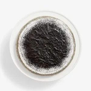 Overhead view of Sesame Mochi Mille Crêpes cake, dark glaze center, sugared edge