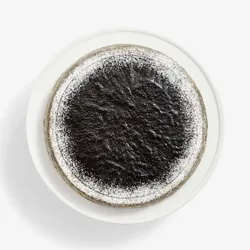 Overhead view of Sesame Mochi Mille Crêpes cake, dark glaze center, sugared edge