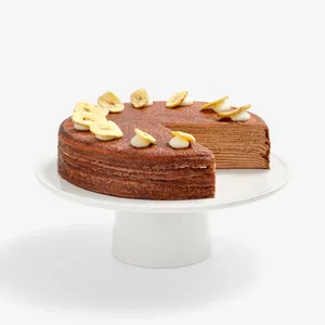 Chocolate Banana Mille Crêpes with a slice removed, revealing layered crêpe interior