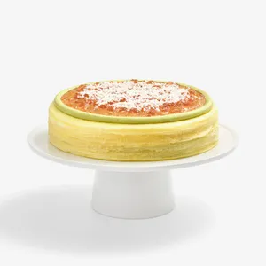 Whole Coconut Matcha Mille Crêpes cake topped with jam and coconut, front view
