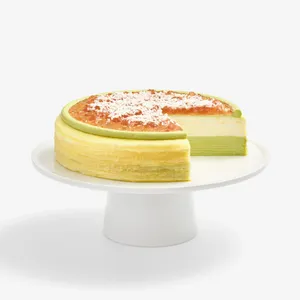 Coconut Matcha Mille Crêpes with a slice removed, revealing layered green and cream interior