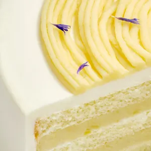 Close-up of whipped cream edge with blue cornflower petals