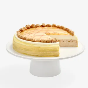 Apple Pie Mille Crêpes on a white cake stand, slice removed to show cream and spiced apple layers
