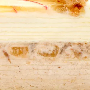 Close-up of crêpe layers with whipped cream and spiced cream studded with diced apple