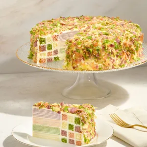 Lady M Birthday Cake 9" on a cake stand with a slice showing checkerboard sponge and crêpe layers