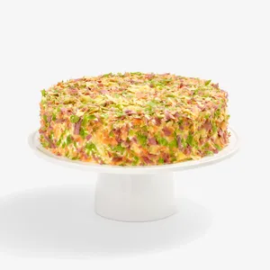 Whole Lady M Birthday Cake 9" covered in colorful crêpefetti on a white cake stand