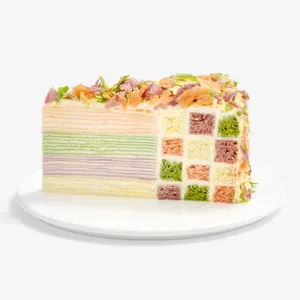 Slice of Lady M Birthday Cake showing rainbow crêpe layers and checkerboard sponge