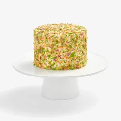 Whole Lady M Birthday Cake 6" covered in colorful crêpefetti on a white cake stand