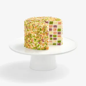 Lady M Birthday Cake 6" with a slice removed, revealing colorful checkerboard sponge