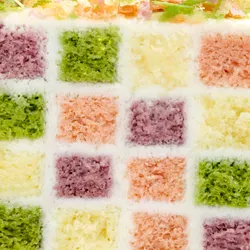 Close-up of pink, purple, green and yellow checkerboard sponge in the Lady M Birthday Cake 6"